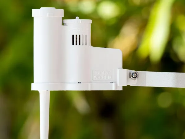 Hunter Rain-Clik Wireless Rain and Freeze Sensor (WRCLIK) — sensor inalámbrico de corte por lluvia y helada para programadores de riego, fotografía del fabricante tomada al aire libre sobre césped